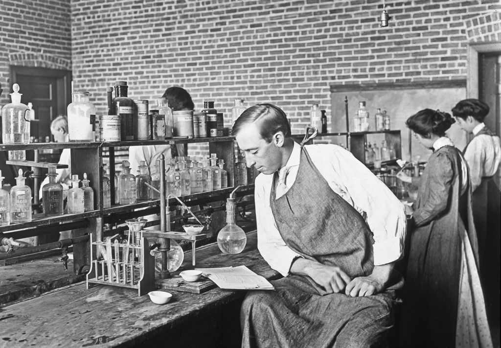 Man looking at book in chemistry lab